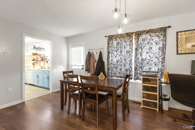 dining room featuring wood finished floors and baseboards