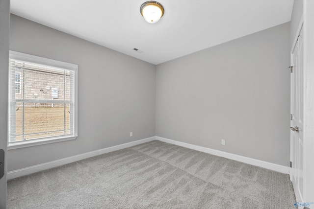 unfurnished room featuring carpet, visible vents, and baseboards