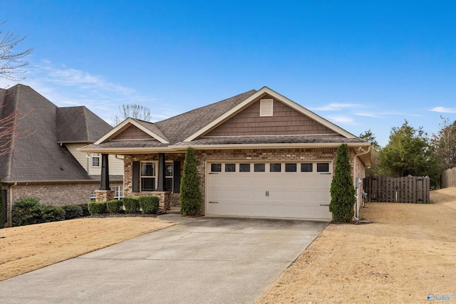 view of front of home with a garage, brick siding, driveway, and fence