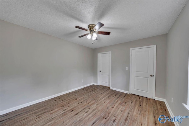 unfurnished bedroom featuring baseboards, wood finished floors, ceiling fan, and a textured ceiling