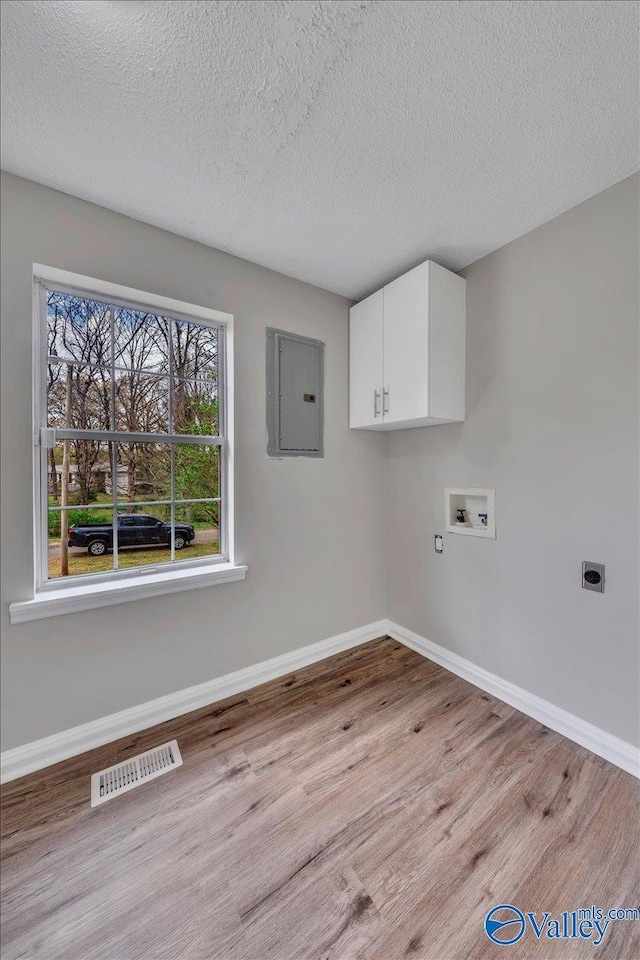 laundry area featuring visible vents, electric panel, hookup for a washing machine, electric dryer hookup, and cabinet space