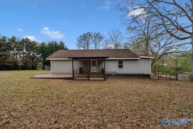 rear view of property featuring a yard, fence, and a deck