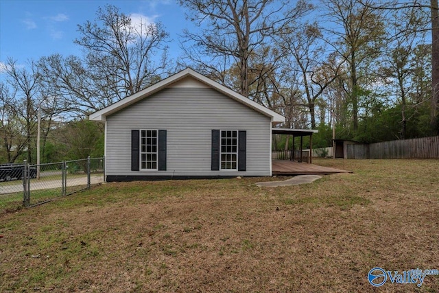 view of property exterior featuring an attached carport, a gate, fence, and a yard