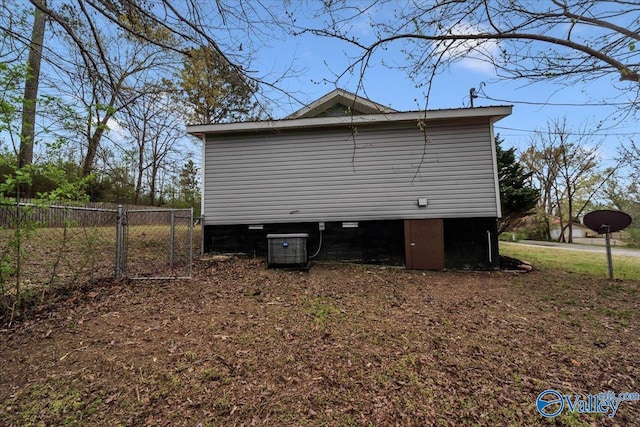 view of side of home featuring fence and central AC