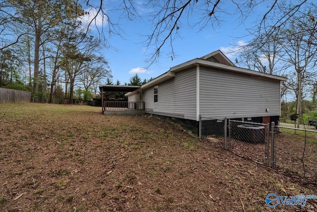 view of side of property with fence and a wooden deck