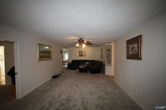 carpeted living area featuring ceiling fan, baseboards, and a textured ceiling