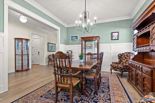 dining room with ornamental molding, a chandelier, and light wood-type flooring