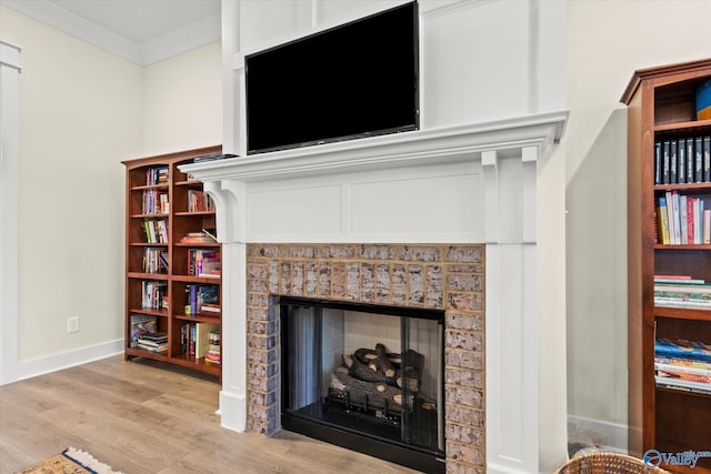 details featuring crown molding, hardwood / wood-style floors, and a brick fireplace