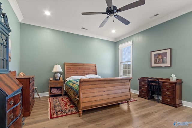 bedroom featuring hardwood / wood-style flooring, crown molding, and ceiling fan