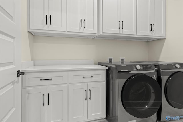 washroom with cabinets and washer and dryer