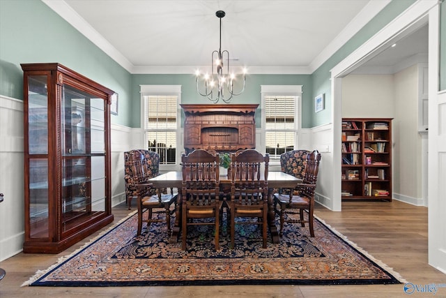 dining space featuring crown molding, hardwood / wood-style flooring, and a chandelier