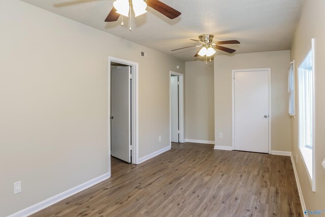 unfurnished bedroom with a textured ceiling, ceiling fan, and light hardwood / wood-style flooring