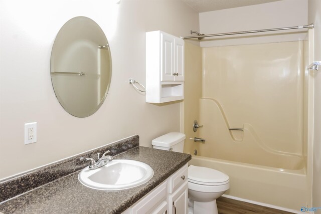 full bathroom with wood-type flooring, shower / bath combination, vanity, and toilet