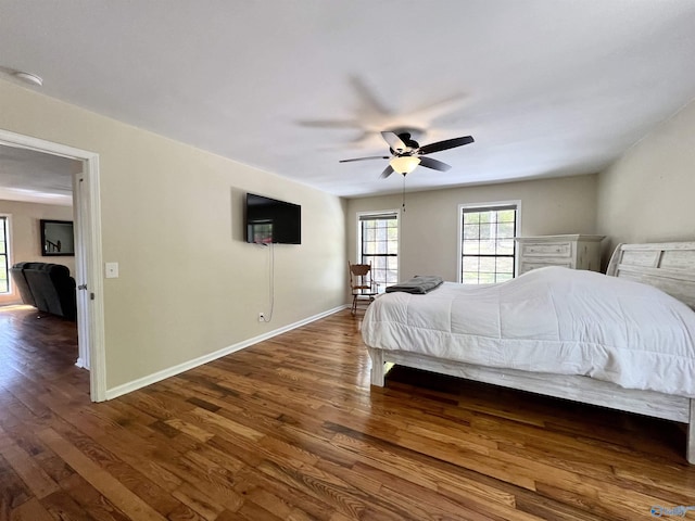 bedroom with ceiling fan, baseboards, and dark wood finished floors