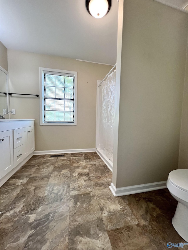 full bath with vanity, baseboards, stone finish flooring, and a shower with curtain