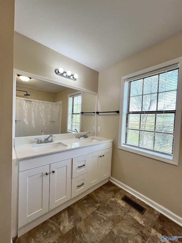bathroom featuring plenty of natural light, visible vents, and a sink