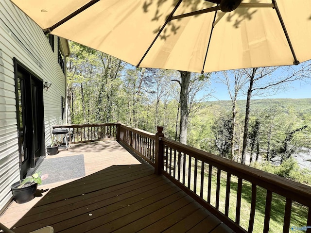 wooden terrace featuring a view of trees