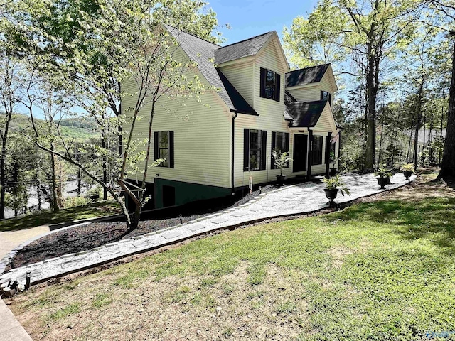 view of property exterior featuring a yard and roof with shingles