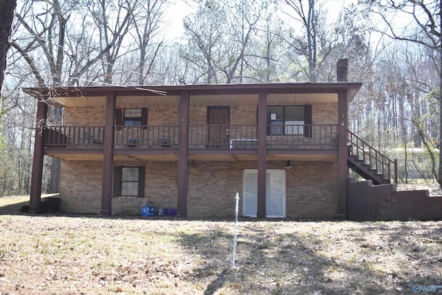 back of property featuring brick siding and stairs