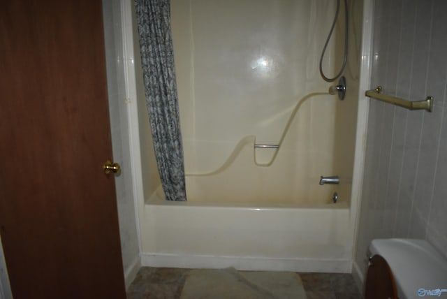 full bathroom featuring wooden walls, shower / bath combination with curtain, and toilet