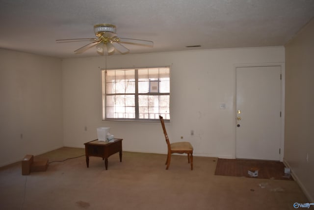 carpeted foyer entrance with visible vents, a textured ceiling, and ceiling fan