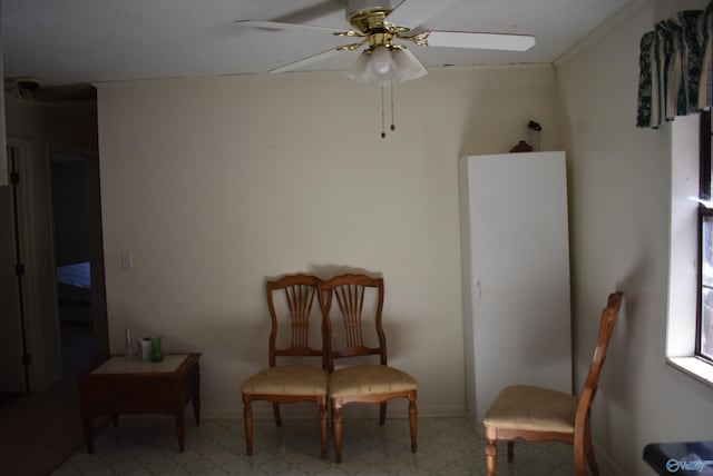 sitting room featuring tile patterned floors, baseboards, and ceiling fan