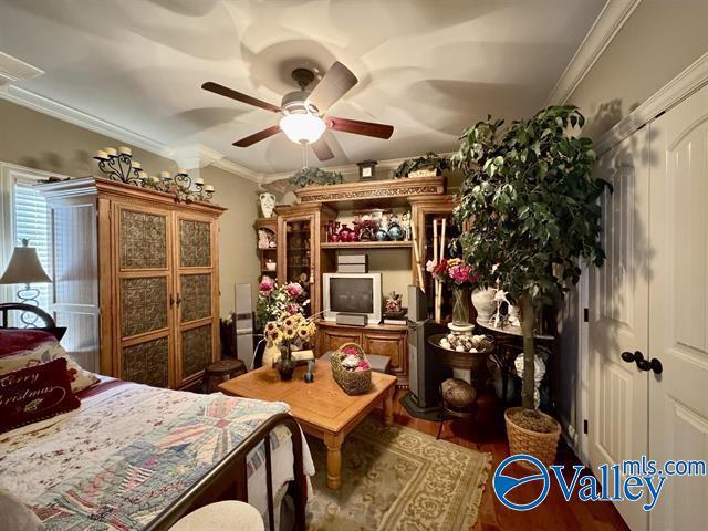 bedroom featuring hardwood / wood-style floors, ceiling fan, and ornamental molding