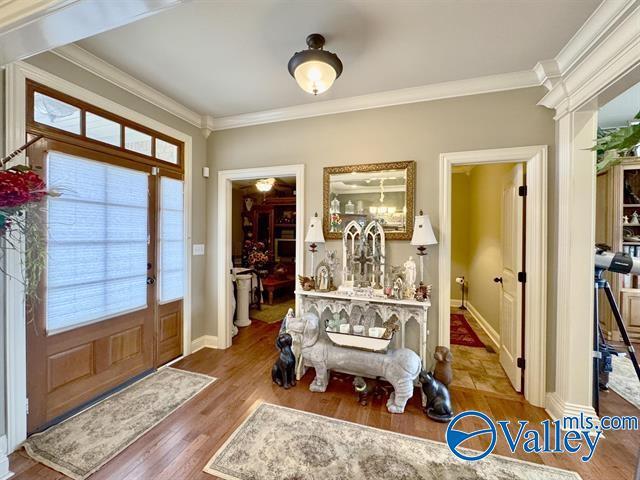 foyer with hardwood / wood-style flooring and crown molding