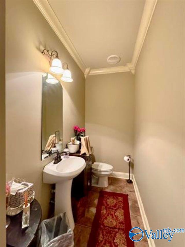 bathroom with toilet and crown molding