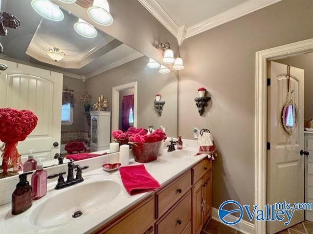 bathroom with a tray ceiling, crown molding, and vanity