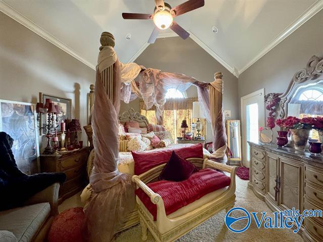 carpeted bedroom featuring ceiling fan, high vaulted ceiling, and ornamental molding