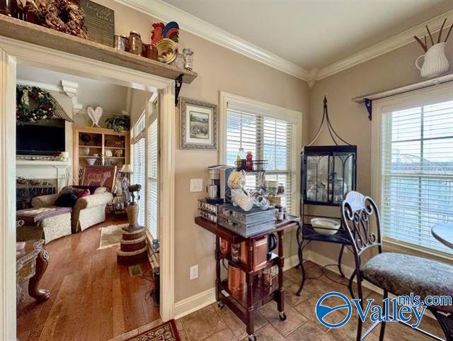 sitting room with tile patterned flooring, ornamental molding, and a wealth of natural light