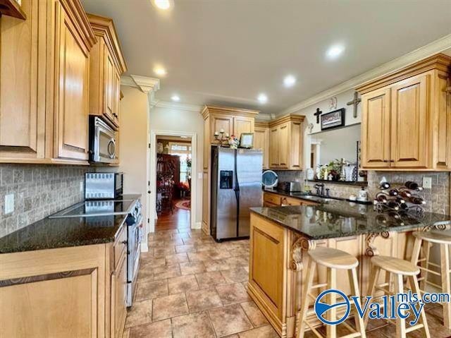 kitchen with a kitchen bar, crown molding, and appliances with stainless steel finishes