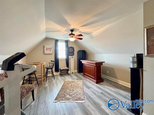 office space with ceiling fan, light hardwood / wood-style flooring, and vaulted ceiling