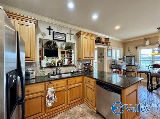 kitchen with hanging light fixtures, sink, ornamental molding, appliances with stainless steel finishes, and kitchen peninsula