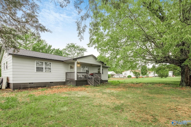 rear view of house featuring crawl space, a lawn, covered porch, and roof with shingles