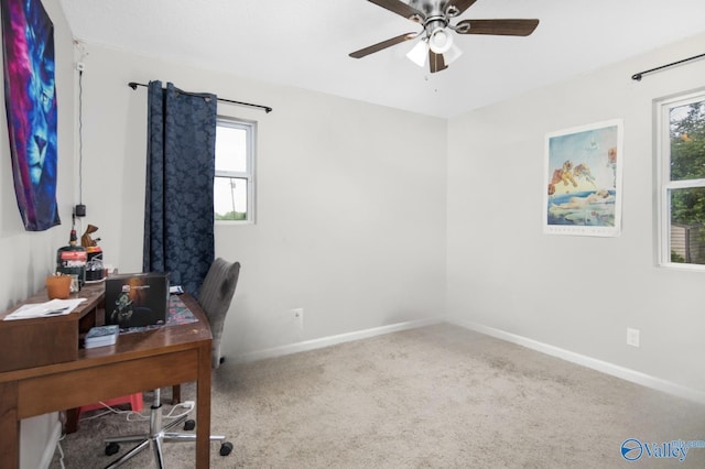 carpeted home office featuring baseboards and ceiling fan