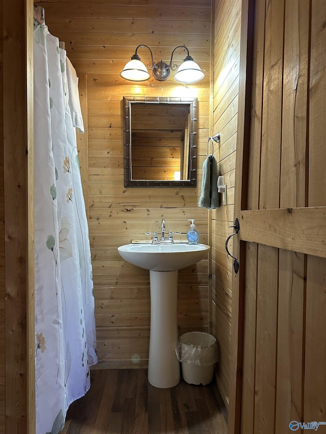 bathroom with wooden walls and wood finished floors