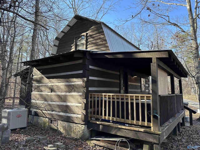 view of side of property with metal roof, crawl space, a gambrel roof, and central air condition unit