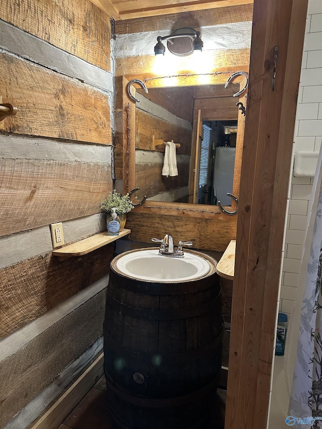 bathroom featuring wood walls and vanity