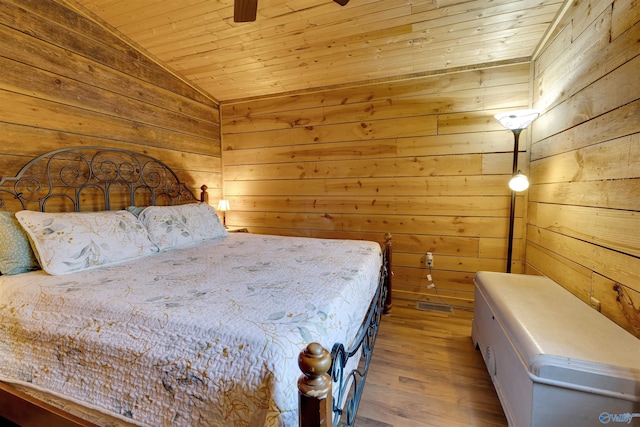 bedroom with lofted ceiling, wooden ceiling, light wood-style flooring, and wooden walls