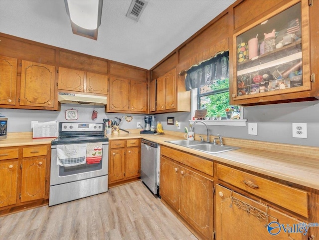 812 Mitwede St SW, Hartselle, AL 35640 - kitchen featuring stainless steel appliances, under cabinet range hood, a sink, brown cabinets, and light countertops