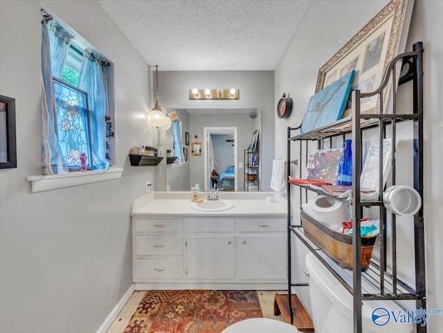 812 Mitwede St SW, Hartselle, AL 35640 - bathroom featuring vanity, toilet, a textured ceiling, and wood finished floors