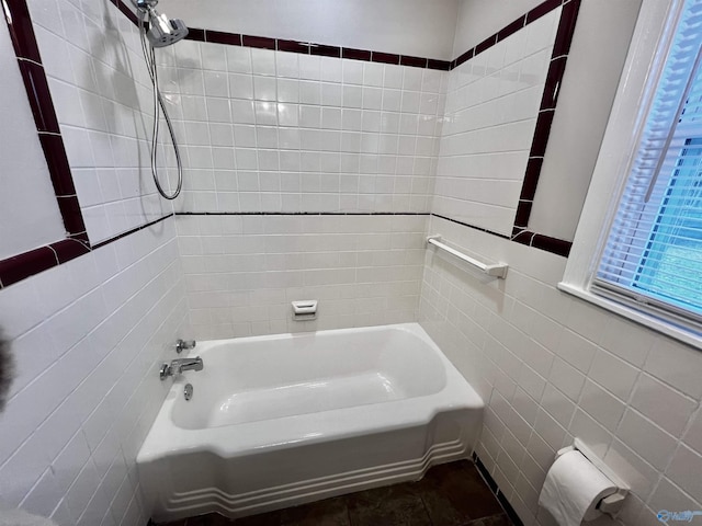 bathroom with tile walls and tiled shower / bath