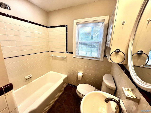 bathroom featuring toilet, tile patterned floors, tile walls, and a bathing tub