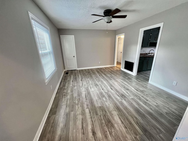 interior space featuring hardwood / wood-style floors, a textured ceiling, ceiling fan, and sink