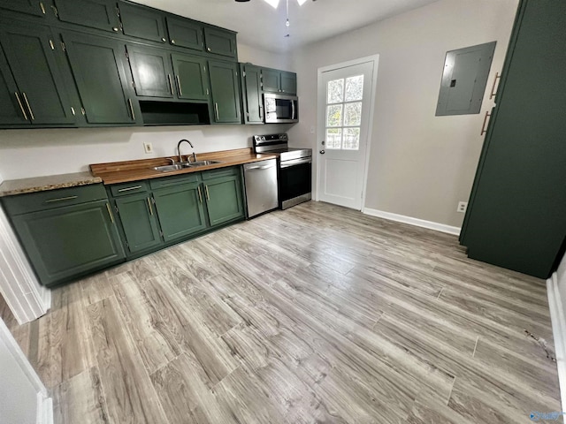 kitchen with electric panel, sink, stainless steel appliances, and light hardwood / wood-style floors