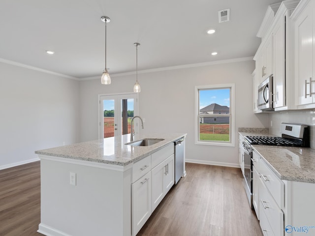 kitchen with french doors, a kitchen island with sink, stainless steel appliances, a sink, and wood finished floors