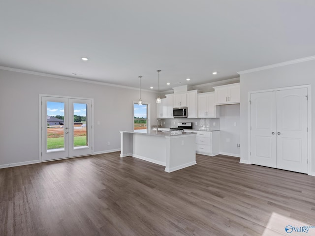 kitchen with an island with sink, crown molding, white cabinets, appliances with stainless steel finishes, and wood finished floors