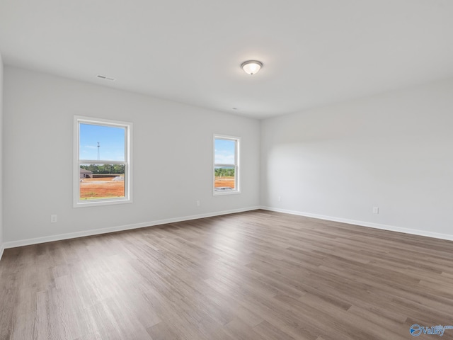 empty room featuring baseboards and wood finished floors
